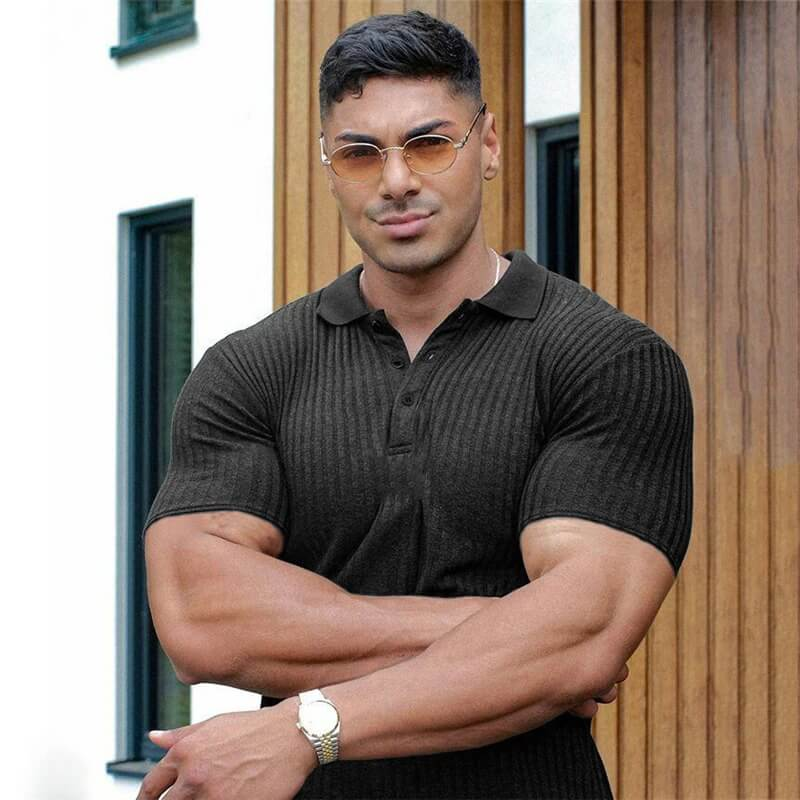 Stylish black polo t-shirt with buttons and stripes, worn by a man, showcasing a modern and sophisticated look against a wooden background.